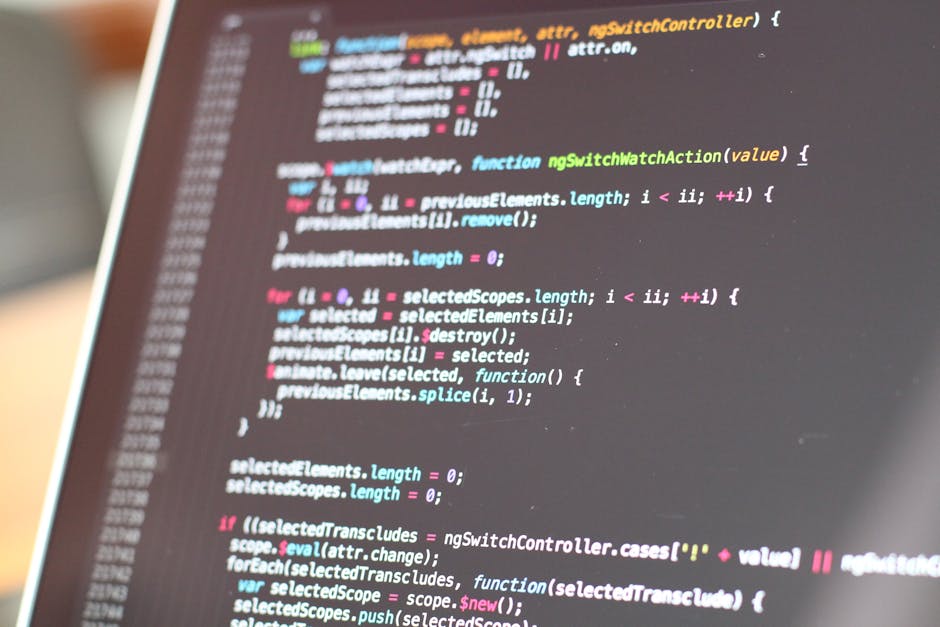 Close-up of a computer screen displaying lines of colorful HTML and CSS code in a dark-themed editor, with a faint blurred reflection of a person in the background. The code features syntax highlighti